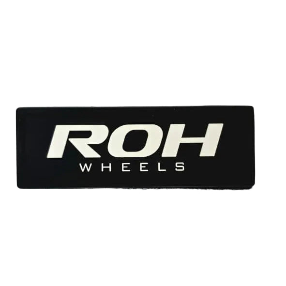 A Rectangular ROH Wheels PVC Patch to be used on your vehicle roof liner, backpack or jackets